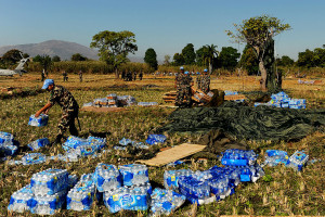 Nepalese soldiers stack water after a U.S. Air Force C-17 Globemaster III aircraft air dropped pallets of water and food in Mirebalais, Haiti, Jan. 21, 2010.